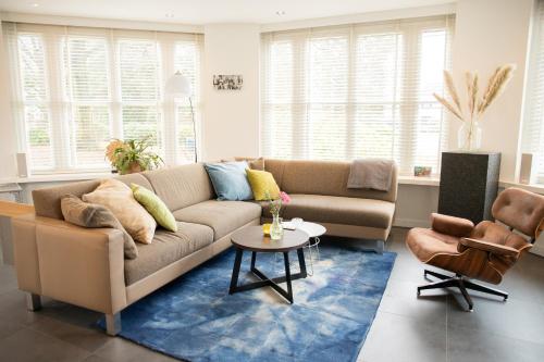 a living room with a couch and a table at Hotel Villa Ruimzicht in Doetinchem