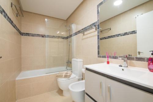 a bathroom with a toilet and a sink and a tub at La Caracola - Espíritu libre A/A in El Altet