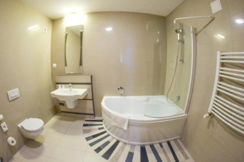 La salle de bains est pourvue d'une baignoire, de toilettes et d'un lavabo. dans l'établissement Hotel Neo, à Tarnowskie Góry