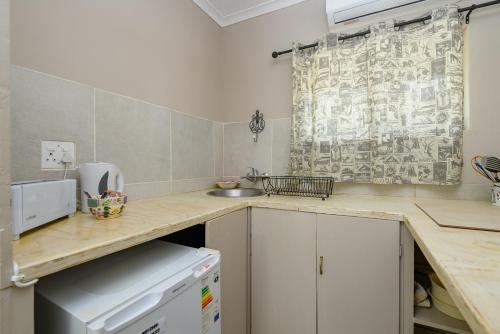 a kitchen with a counter top and a sink at Hlulala Guest House in Hluhluwe