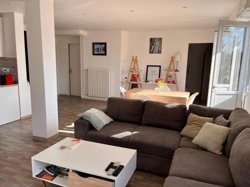 a living room with a couch and a table at Residence Le Canal Strasbourg - Moderne avec Parking in Bischheim