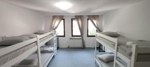 a room with two bunk beds and two windows at Hostel Center Luxury in Sarajevo