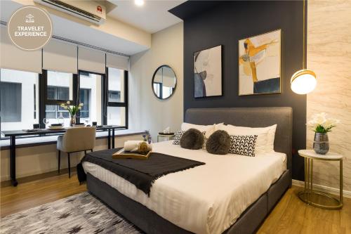 Schlafzimmer mit einem Kingsize-Bett und einem Schreibtisch in der Unterkunft Ceylonz Suite KLCC, Travelet in Kuala Lumpur