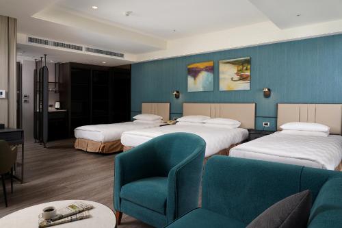 a hotel room with two beds and a chair at E-DA Skylark Hotel in Dashu