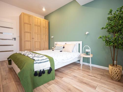 sypialnia z łóżkiem i zieloną ścianą w obiekcie OAK TREE Apartment w mieście Dąbrowa Górnicza