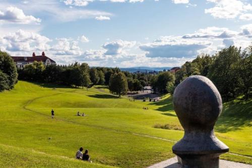 a statue of a head in a field of grass at Stylish 3-room apartment with balcony and free parking in Oslo