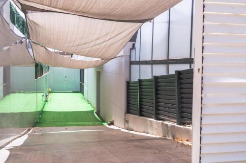 un edificio con toldo sobre un pasillo con suelo verde en Luxurious Villa Marly II, en Castelldefels