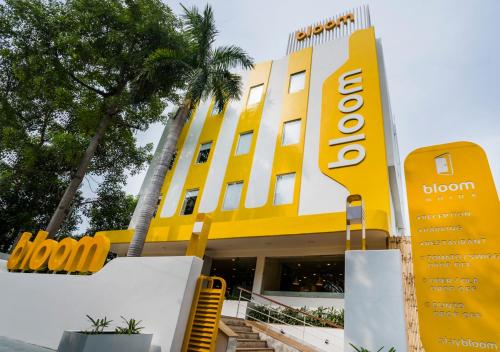 a yellow building with a sign in front of it at Bloom Hotel - Sector 19 in Noida