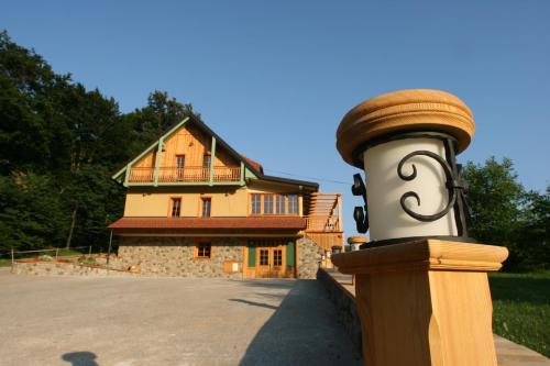 a wooden post with a house in the background at Villa Les with Hot tub & Sauna in Brežice
