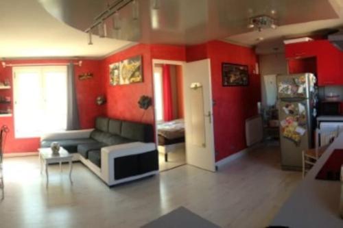 - un salon avec un canapé et des murs rouges dans l'établissement T2-42m2-Climatisation, lumière tamisée-garage, à Bourgoin-Jallieu
