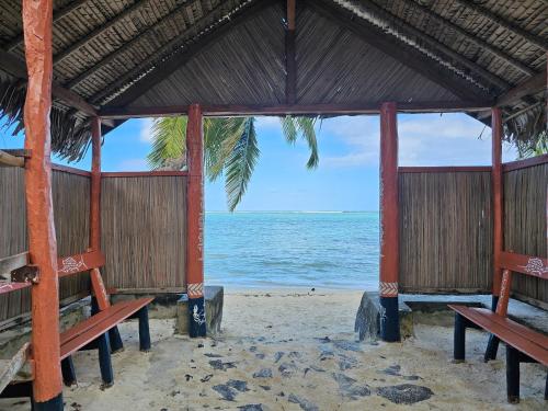 two benches on a beach with the ocean at KINTANA LODGE in Ile aux Nattes