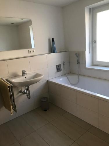a white bathroom with a sink and a bath tub at Unterkunft in Wiesent für Handwerker-/Monteure Berufsreisende in Wiesent