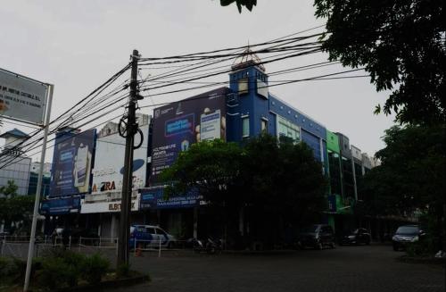 a large blue building with a clock tower on it at OYO Life 92878 Kost Padma Syariah in Kandang-besar