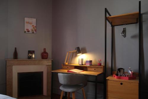 a room with a desk with a chair and a fireplace at L'Iliade - Chambres d'hôtes - B&B à Bouzy in Bouzy