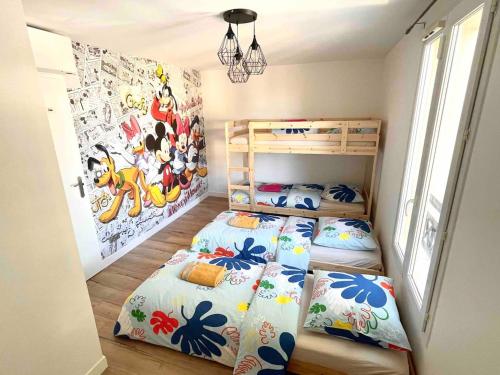 une chambre avec deux lits superposés dans une pièce dans l'établissement Family Disney house, à Magny-le-Hongre
