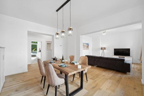 a dining room and living room with a table and chairs at Infinity Stay: Ferienappartments Rheinstrasse in Wilhelmshaven
