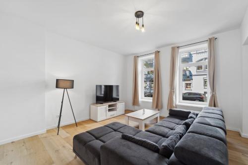 een woonkamer met een bank en een tv bij Infinity Stay: Ferienappartments Rheinstrasse in Wilhelmshaven