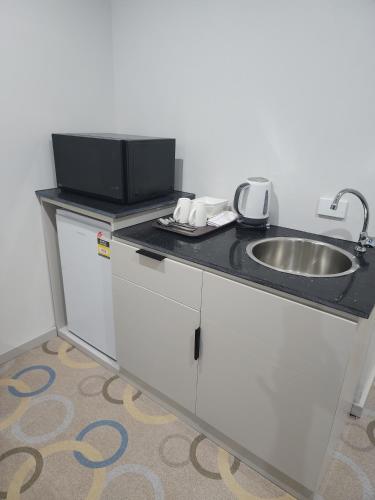 a kitchen with a sink and a counter top at Vualiku Hotel & Apartments in Nadi