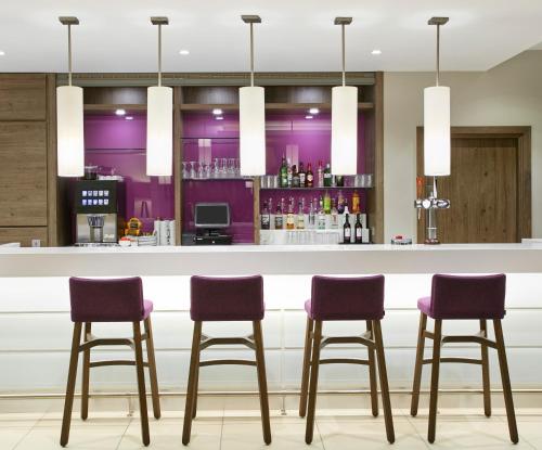 a bar in a hotel with purple bar stools at Hampton by Hilton Oxford in Oxford