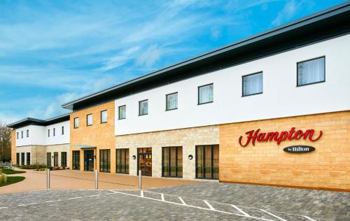a building with a pharmacy sign on the side at Hampton by Hilton Oxford in Oxford