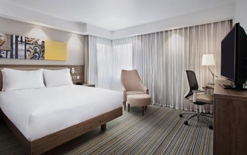 a hotel room with a bed and a desk and a computer at Hampton by Hilton Oxford in Oxford