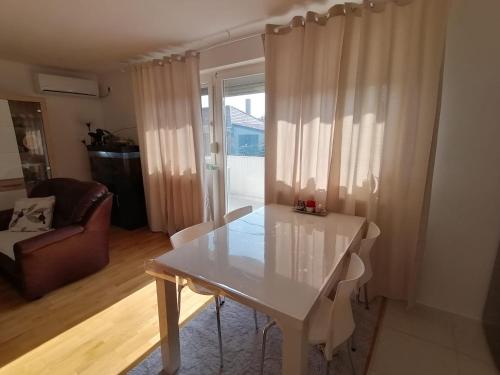 a white table and chairs in a living room at Airport Apartment in Surčin