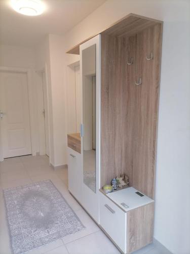 a room with a large wooden cabinet with a mirror at Airport Apartment in Surčin