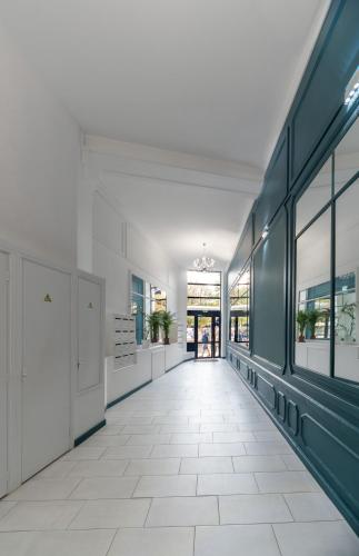 an empty hallway of a building with windows and a hallwayngth at Le Wilson - Appartement design - Hyper centre in Vichy