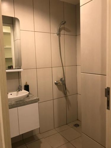 ein Bad mit einer Dusche und einem Waschbecken in der Unterkunft Apartment Grand Kamala Lagoon By Davalina Rooms in Pulosirih