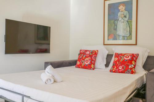 um quarto com um sofá com duas almofadas vermelhas em « Hawai » Proche Mer, Calme, Piscine em Menton