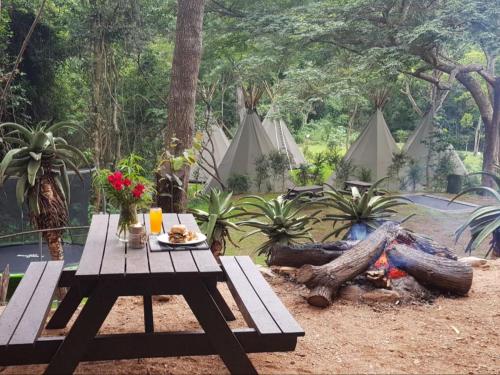 a picnic table with a plate of food next to a fire at Gibaland in Pinetown