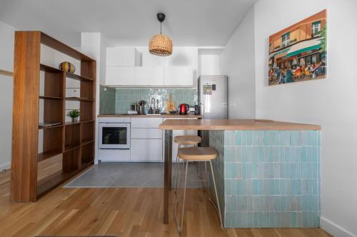a kitchen with a counter and a refrigerator at Le Wilson - Appartement design - Hyper centre in Vichy