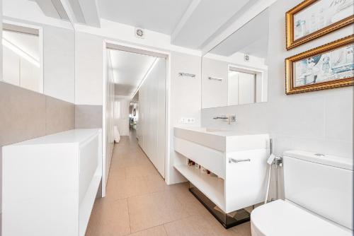 a white bathroom with a sink and a toilet at Luxury First Line Apartment. in Salinetas
