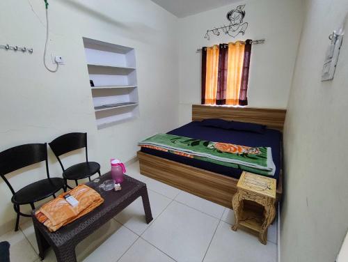 - une chambre avec un lit, une table et des chaises dans l'établissement OYO Ambika Guest House, à Pushkar