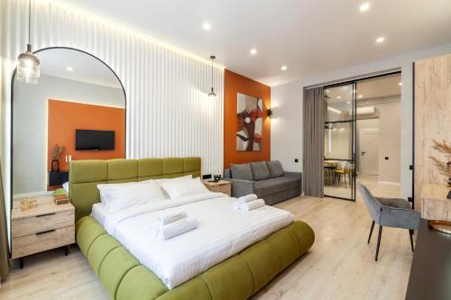 een slaapkamer met een groot bed en een groene bank bij Avangard on Leinberg St 7 Apart in Lviv