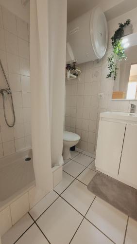 een witte badkamer met een toilet en een wastafel bij Happy Home in Pontault-Combault