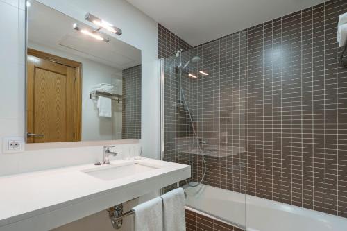 a bathroom with a sink and a shower and a mirror at Apartamentos Solecito in Port d'Alcudia