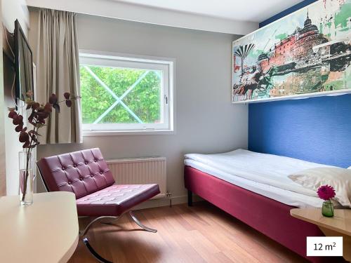 エレブルーにあるGood Morning Örebroのベッドと椅子付きの小さな部屋です。