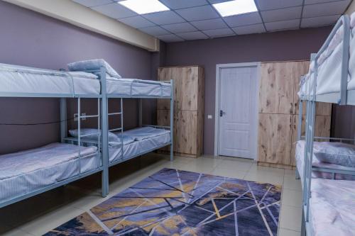 a room with two bunk beds and a door at Mouse House Hostel in Almaty