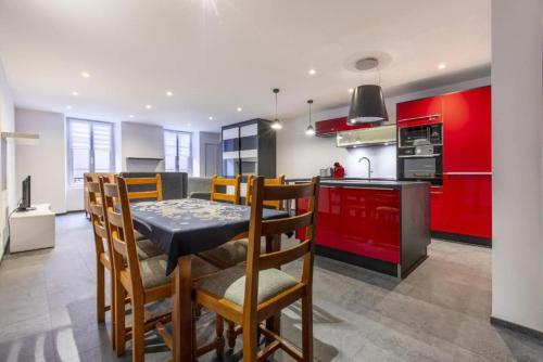 une cuisine avec des armoires rouges et une table et des chaises dans l'établissement Le Romantique, à Annecy