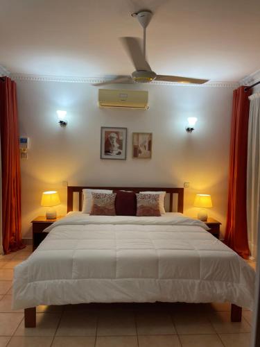 1 dormitorio con 1 cama grande y 2 lámparas en 3-bedroom apartment by Mas, en Dar es Salaam
