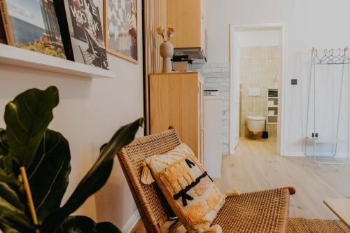 uma cadeira de vime numa sala de estar com uma planta em sleepArt hygge em Celle