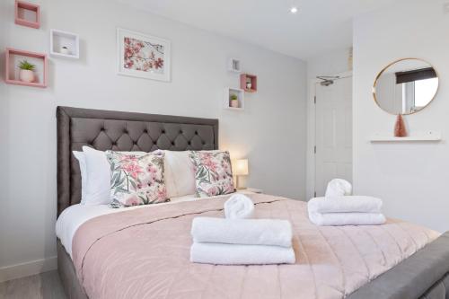 - une chambre avec un grand lit et des serviettes dans l'établissement Stunning Ensuite Room Crystal Palace London SE20, à Londres