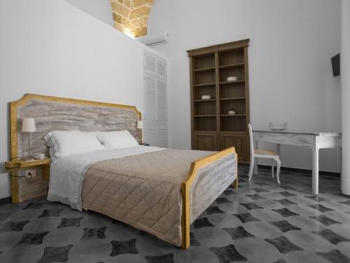 a bedroom with a bed and a desk and a table at B&B Virò in Campi Salentina
