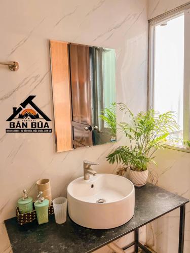 a bathroom with a sink and a mirror and plants at Homestay Bản Búa in Mộc Châu