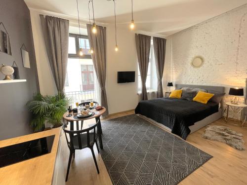 - une chambre avec un lit et une table dans l'établissement Piotrkowska Studio Apartments, à Łódź