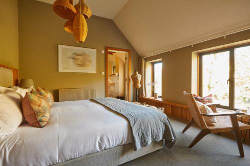 a bedroom with a bed and a chair and a window at Timbrell's Yard in Bradford on Avon