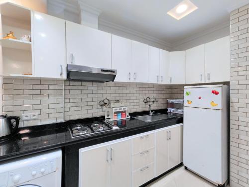 a kitchen with white cabinets and a white refrigerator at Tangier Center Free Parking in Tangier