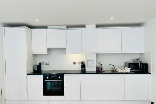 een witte keuken met witte kasten en apparaten bij Borough Central London in Londen
