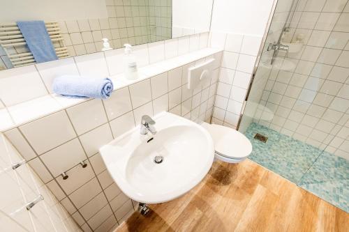 a white bathroom with a sink and a toilet at Steger-Hüs Wohnung 02 in Rantum
